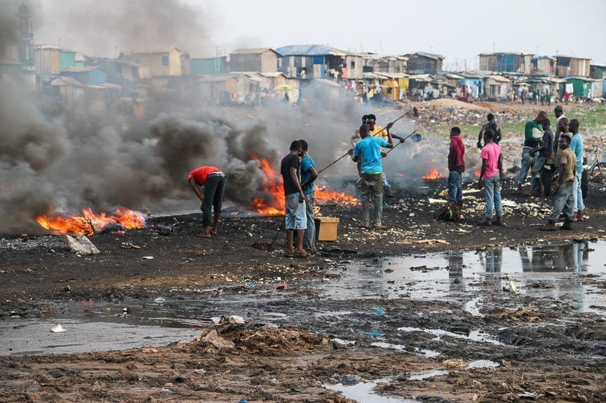Young men at the dump site at Agbobloshie, Accra burning e-waste to recover copper
