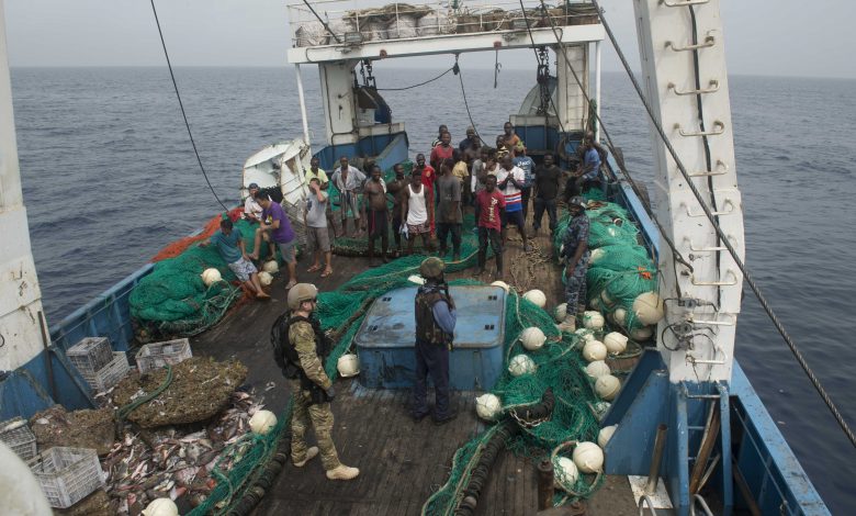 Ghanaian navy and US coast guard officers board a fishing vessel in the Atlantic in 2016 Photograph by Amy M Ressler Alamy